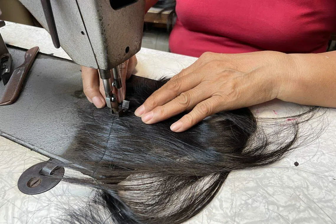 募集到的发束还得经过整理和挑选，才能制作成假发。（Project Haircatchers提供）