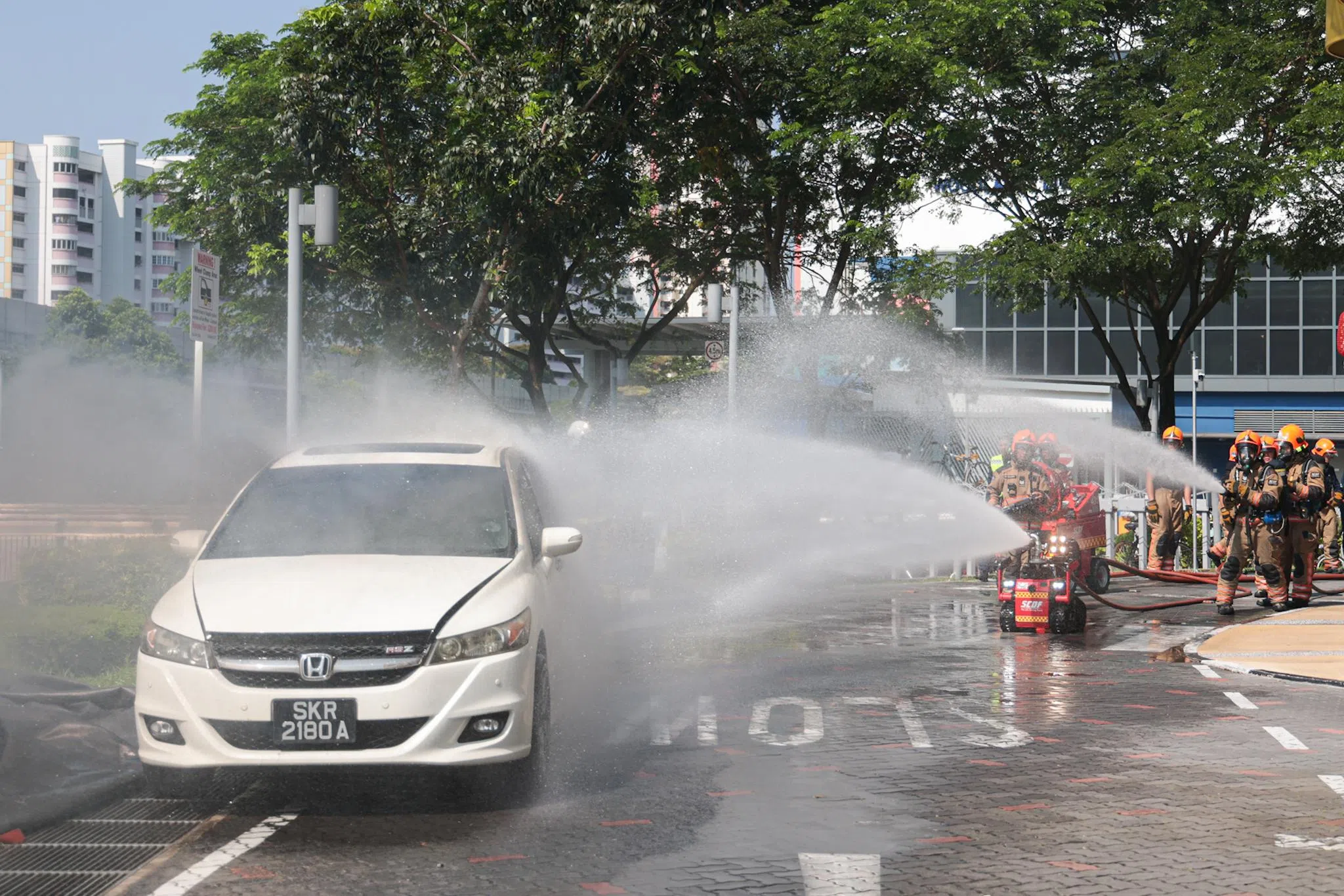 演习开始后，一名可疑人物逐渐靠近一辆车，车子随即起火，冒起浓烟。民防人员迅速到场扑灭火源。（李冠卫摄）