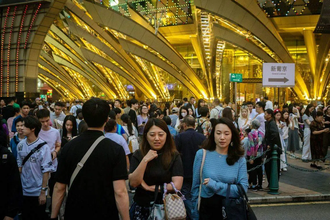 中国五一黄金周入境澳门的旅客量理想，继续为香港股市的博彩股带来支持。图为5月2日澳门新葡京赌场外人流如潮。（彭博社）