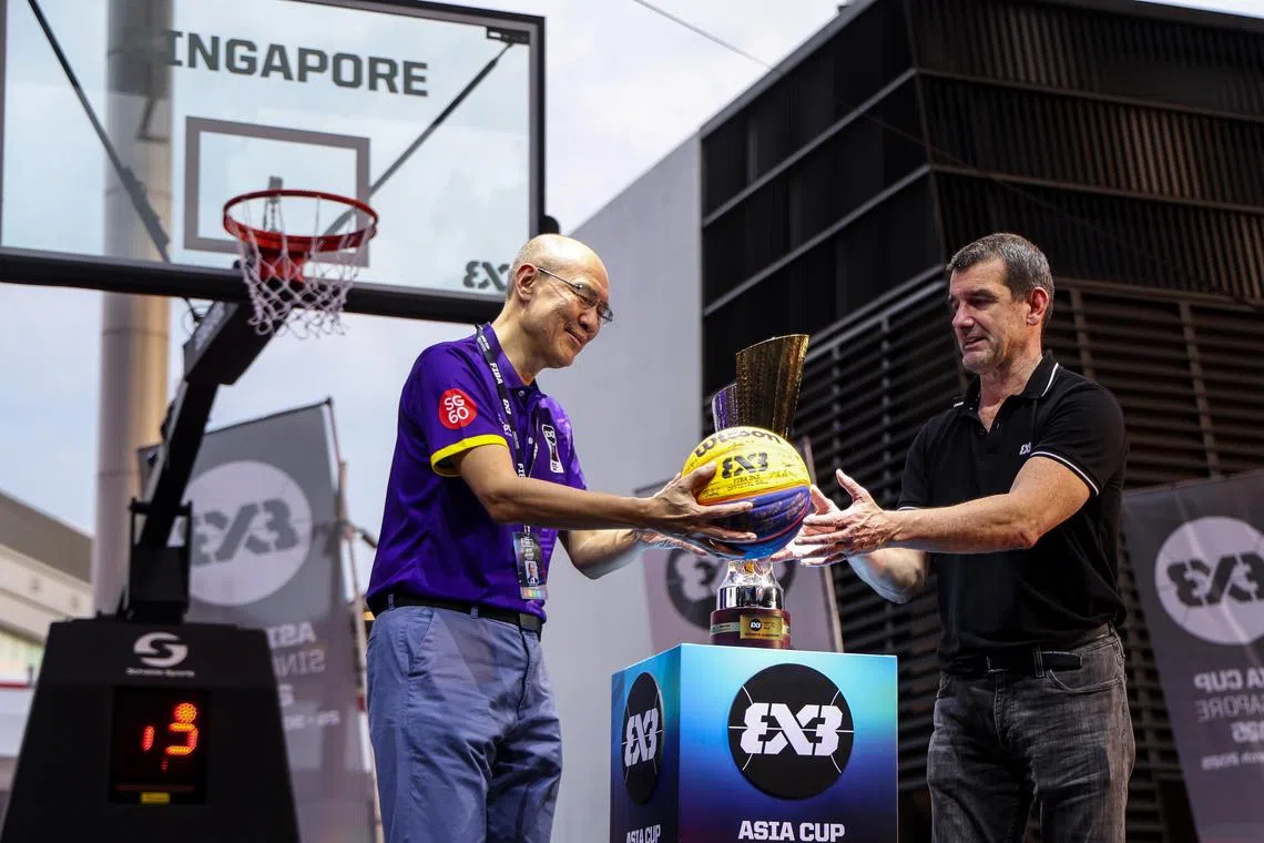 新加坡体理会主席官荣堂（左）和国际篮联三人篮球赛事总监桑切斯（右）在开幕礼上捧起球员签名篮球，宣告双方合作的进一步深化。（白艳琳摄）