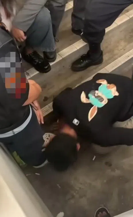 被欺负的少年遭一群人强迫舔一名女生的鞋子。被欺负的少年看来很惊恐，但不敢反抗。（网络视频截图）