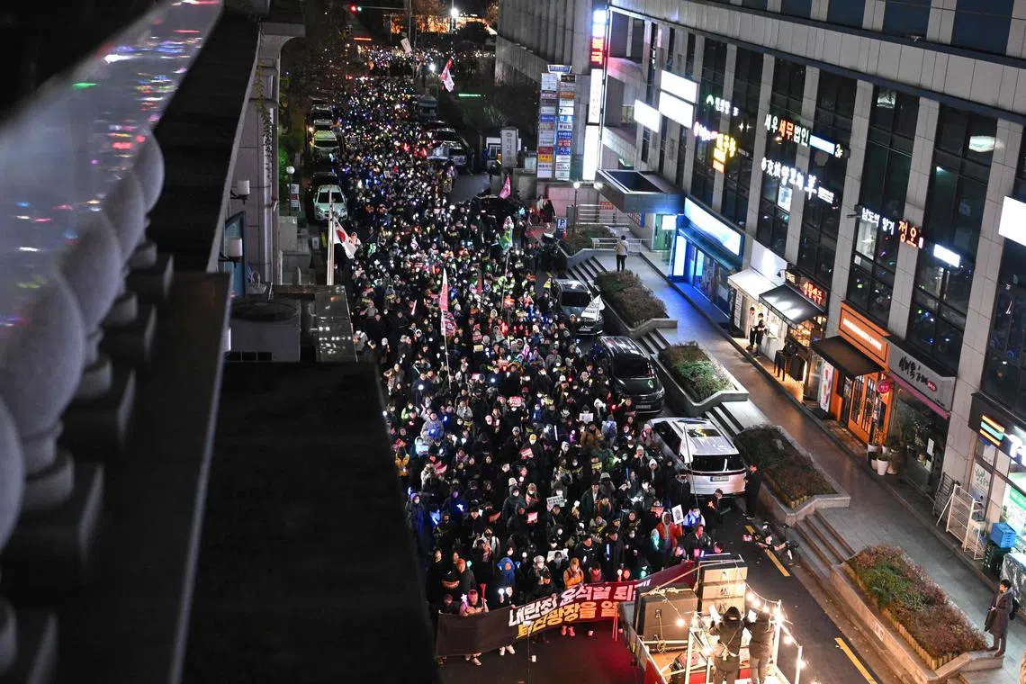 韩国示威者星期五（12月13日）游行到执政党总部，试图对执政党议员施压，要他们支持弹劾案。（法新社）
