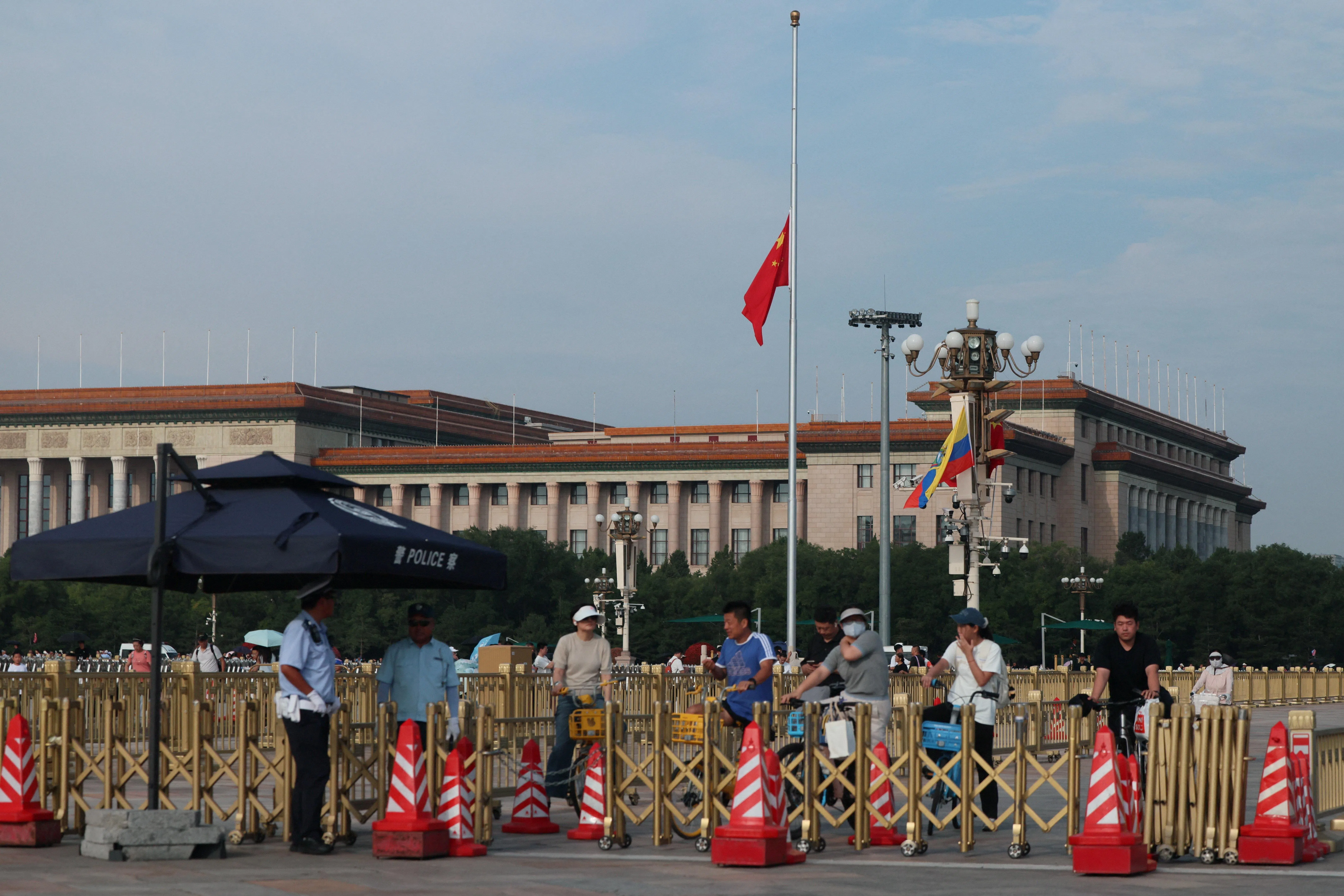 中国国务院原总理朱镕基遗体星期二（8月18日）在北京火化，首都天安门广场等地降半旗志哀。朱镕基上星期三（12日）去世，享年98岁。图为市民在北京人民大会堂外的警岗围栏处等候交通灯转绿。（路透社）