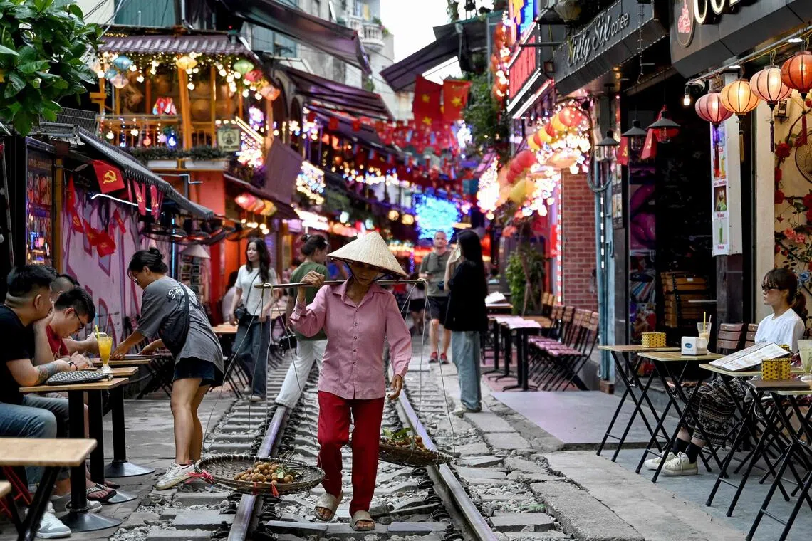 “火车街”的铁轨虽然老旧，但仍照常运作。没有火车经过时，当地小贩、游客能随意在轨道上行走，形成河内一道独特的风景。（法新社）