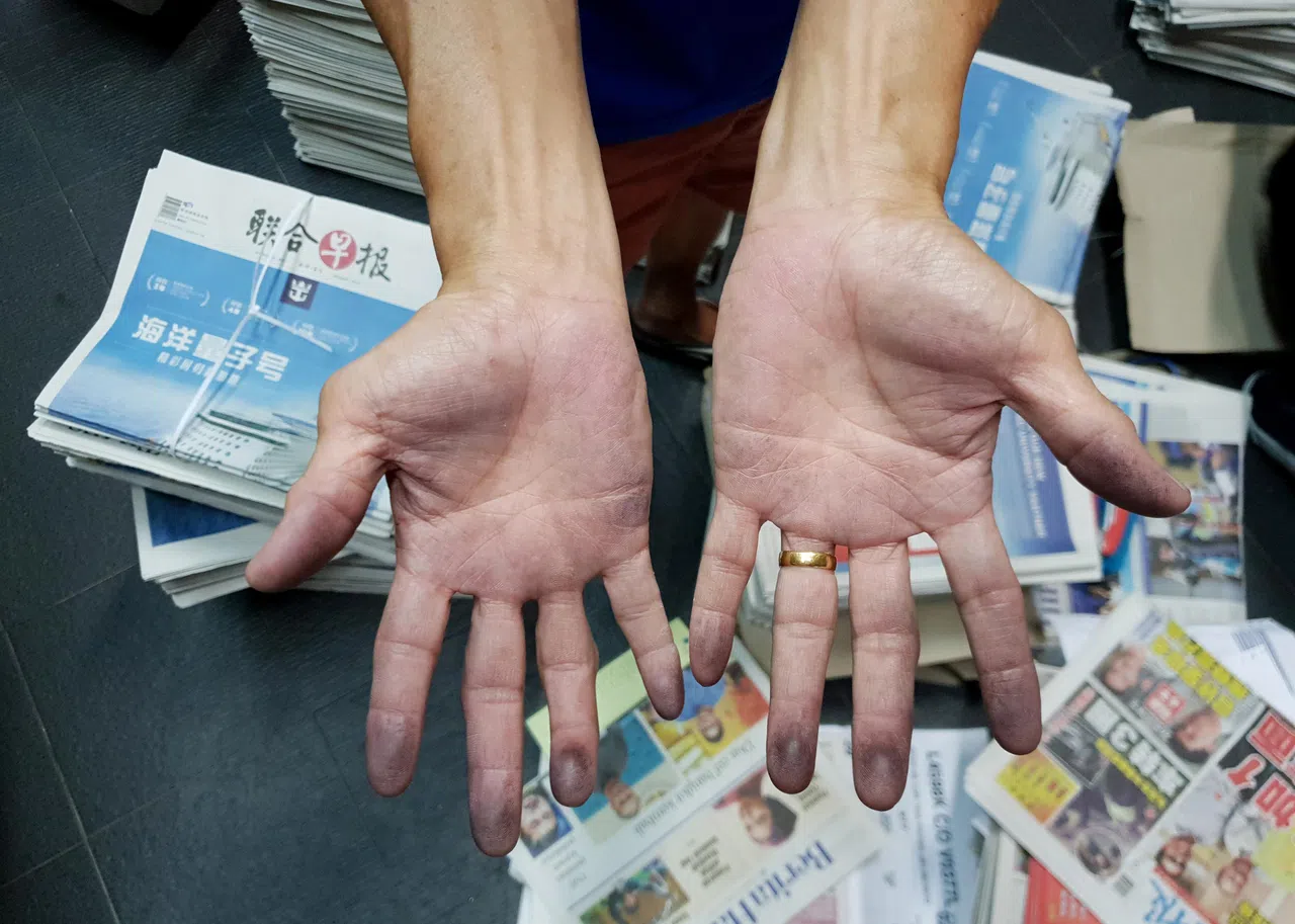 何益华这双手沾染报纸墨香40余年。他风雨不改坚持派报，将三个孩子培育成才。（白艳琳摄）