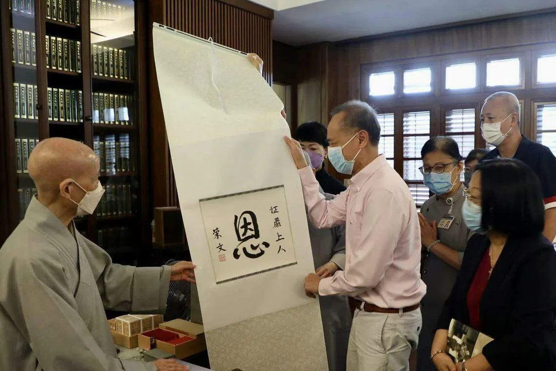 杨荣文（前排中）星期一（9月11日）携太太梁利平（前排右）和小儿子杨时弘到花莲慈济静思精舍，向证严法师（左）送上他的亲笔书法，以“恩”字表达对慈济牵线为杨时弘找到骨髓捐献者的感激。（杨荣文脸书）