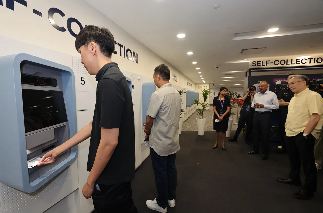 国家安全统筹部长兼内政部长尚穆根（右二）星期四（7月31日）为移民与关卡局新服务中心揭幕，参观证件的自助领取机。（邬福梁摄）