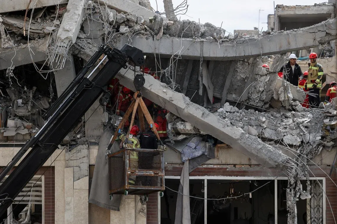 美伊战事仍然激烈，伊朗首都德黑兰星期五（3月27日）一处民宅被炸，救援人员废墟中救出伤者。（路透社）