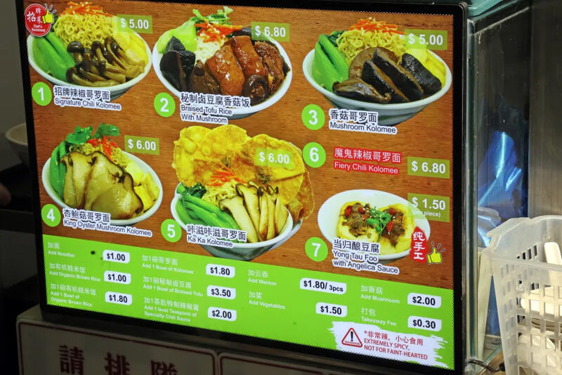 纯素档口的餐牌上注明“加一茶匙特制辣椒酱”收费两元。（刘启成摄）