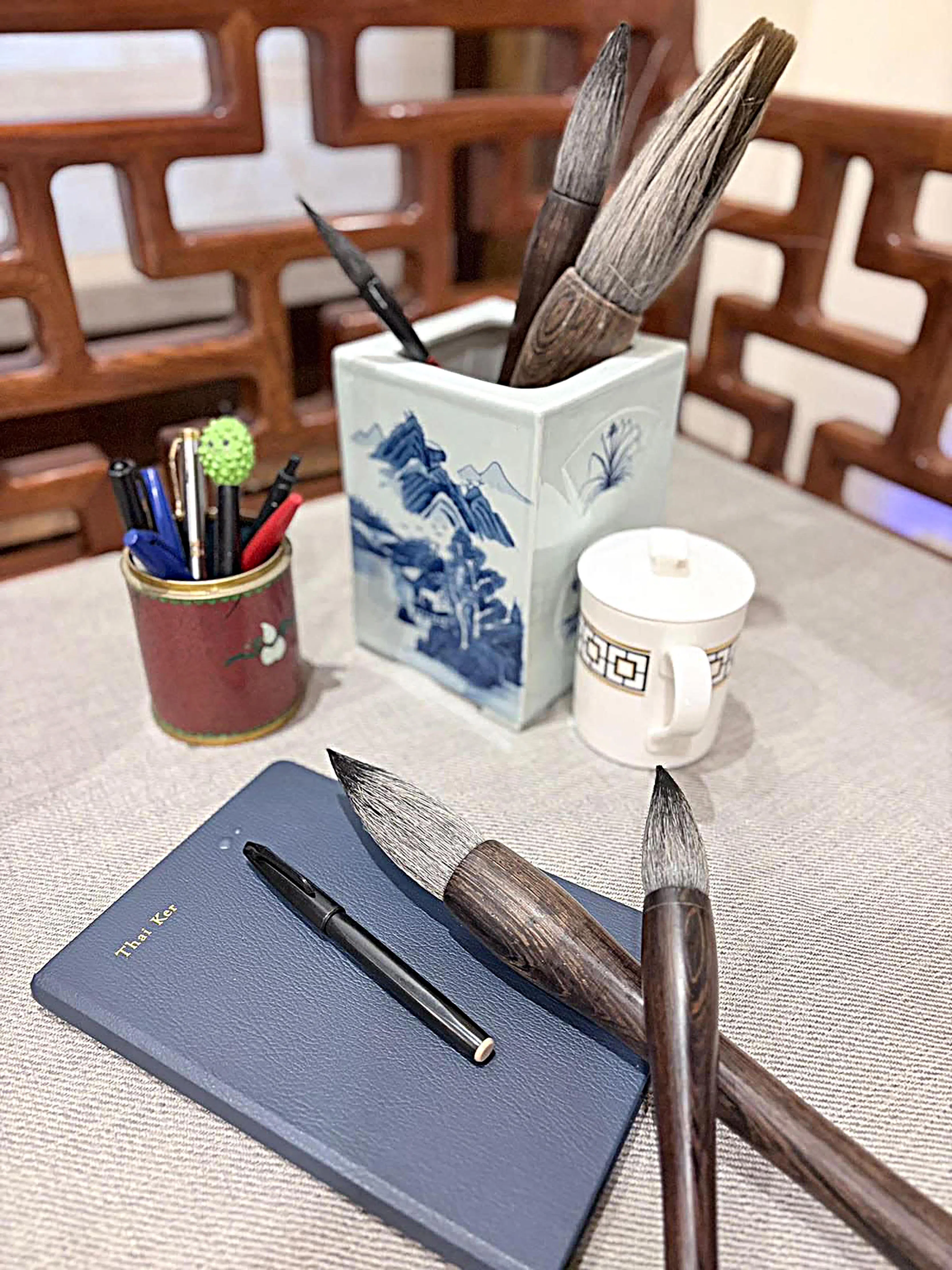 灵堂纪念桌上摆放着刘太格的个人物品，包括水杯、毛笔、速写本，钢笔等。（余明飞摄）