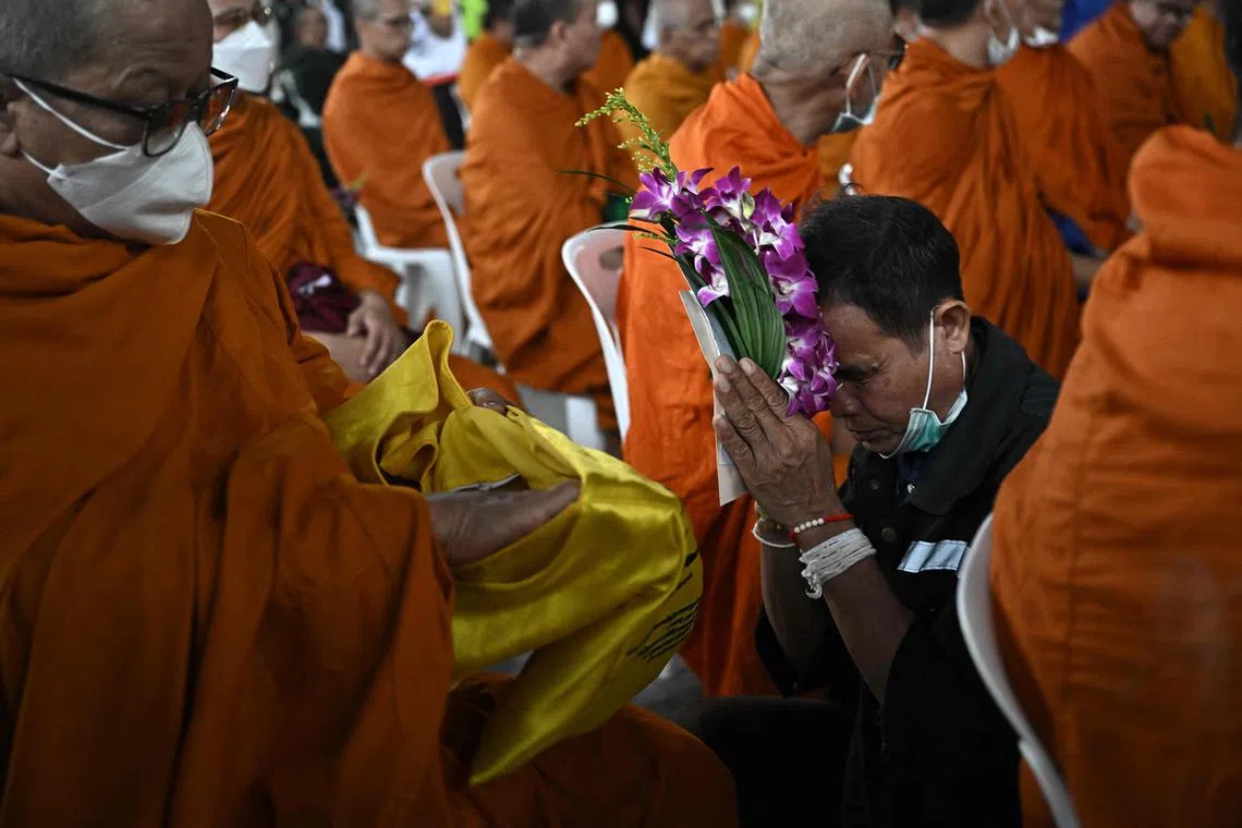 曼谷金佛寺的僧侣星期四（4月10日）到塌楼旁为遇难者诵经，遇难者家属也参加了仪式。（法新社）