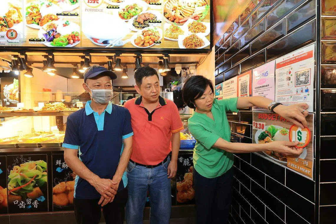 沈颖（右一）到盛港西的大食汇咖啡店参观时说，新的网站目前涵盖约40家咖啡店，未来几年将陆续扩展至全岛所有374间。（唐家鸿摄）