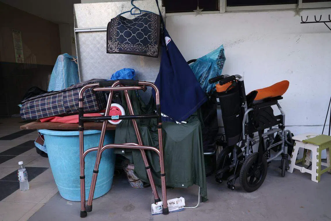 事发单位外堆放着两辆轮椅、助行器和杂物。邻居透露，身材瘦削的女死者不良于行，男嫌凶可缓慢行走，但近年来失智症病情愈发严重。（白艳琳摄）