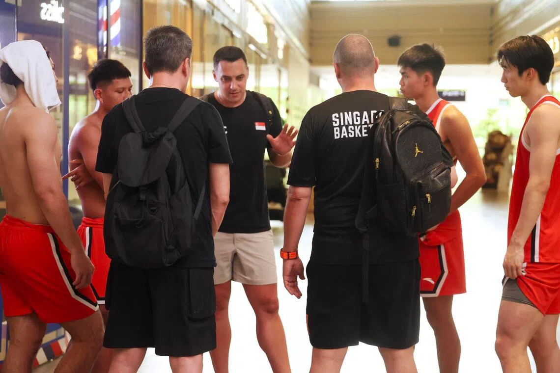 比赛结束后，我国教练拉西奇（中）和队员们在球场旁边进行了快速复盘，总结球队在本场比赛的不足。（郑一鸣摄）