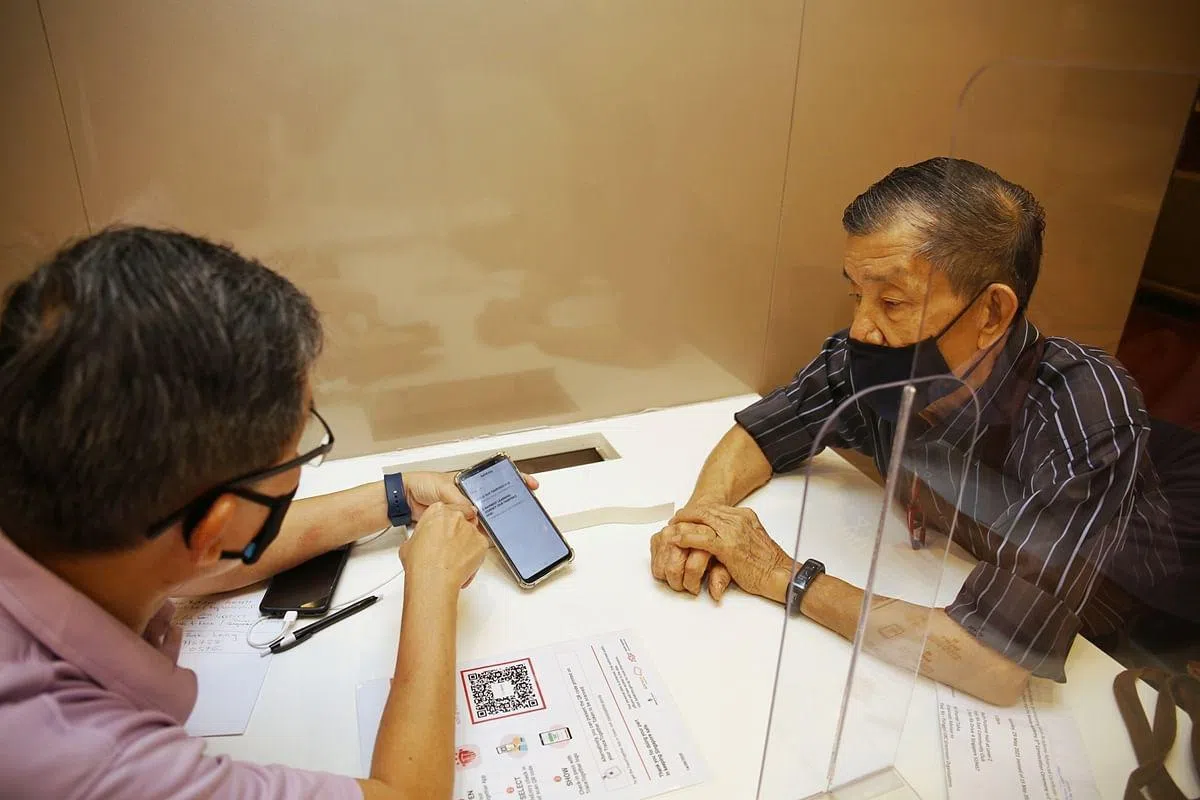 退休人士陈木龙（右）约一年前参加了资媒局的数码乐龄计划，至今已完成约12堂课程，学到数码内容涵盖手机的各种功能和应用，以及电子付费方式等。（白艳琳摄）