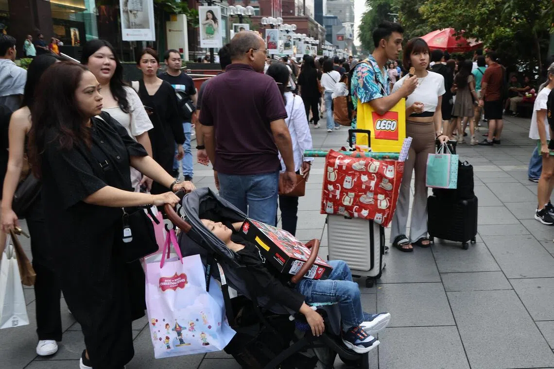 圣诞节前最后一个周末，民众穿梭在乌节大街，边逛边选购圣诞礼品，为来临的圣诞节做准备。（梁麒麟摄）
