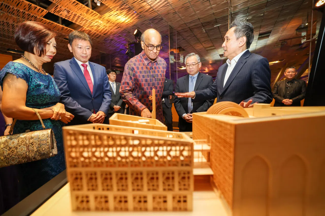 建筑师郑肖思（右一）在颁奖礼会场设立的模型建筑旁为尚达曼总统（中）讲解他的设计。（陈斌勤摄）