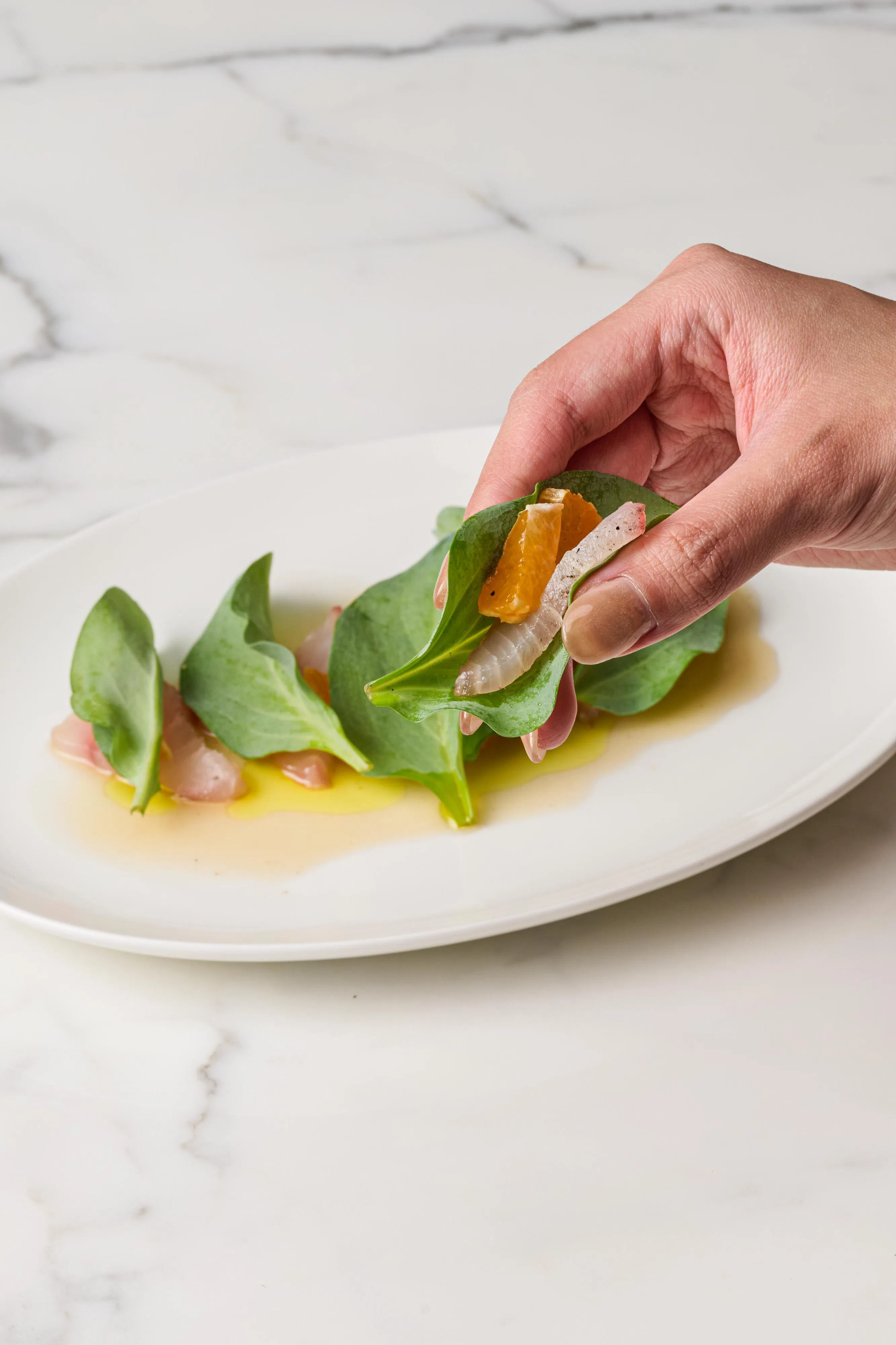 石斑鱼刺身搭配生蚝叶和柑橘，清甜爽口。（餐馆提供）