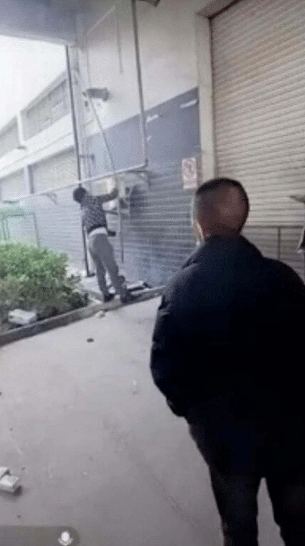  一名工人试图用长棍砸毁工厂的监控摄像头。（互联网） 