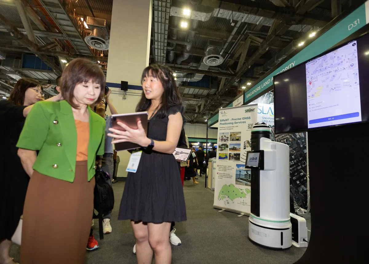 永续发展与环境部兼交通部高级政务部长许连碹博士（左）出席地理空间和定位科技会展，了解土管局展开的无障碍路线地图项目。（张思庆摄）