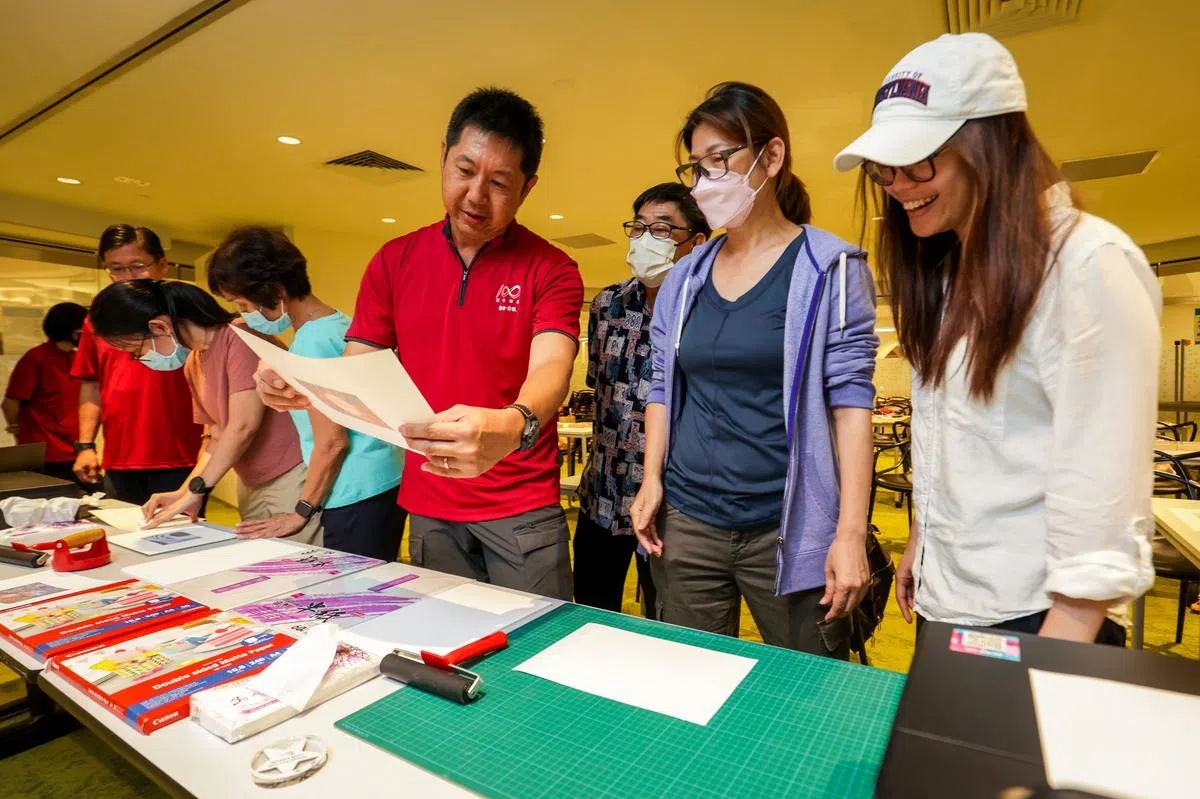 参与工作坊的读者通过早报高级摄影记者蔡家增（右四）的示范和引导下学习，再亲自动手进行图像转印工作。（叶振忠摄）