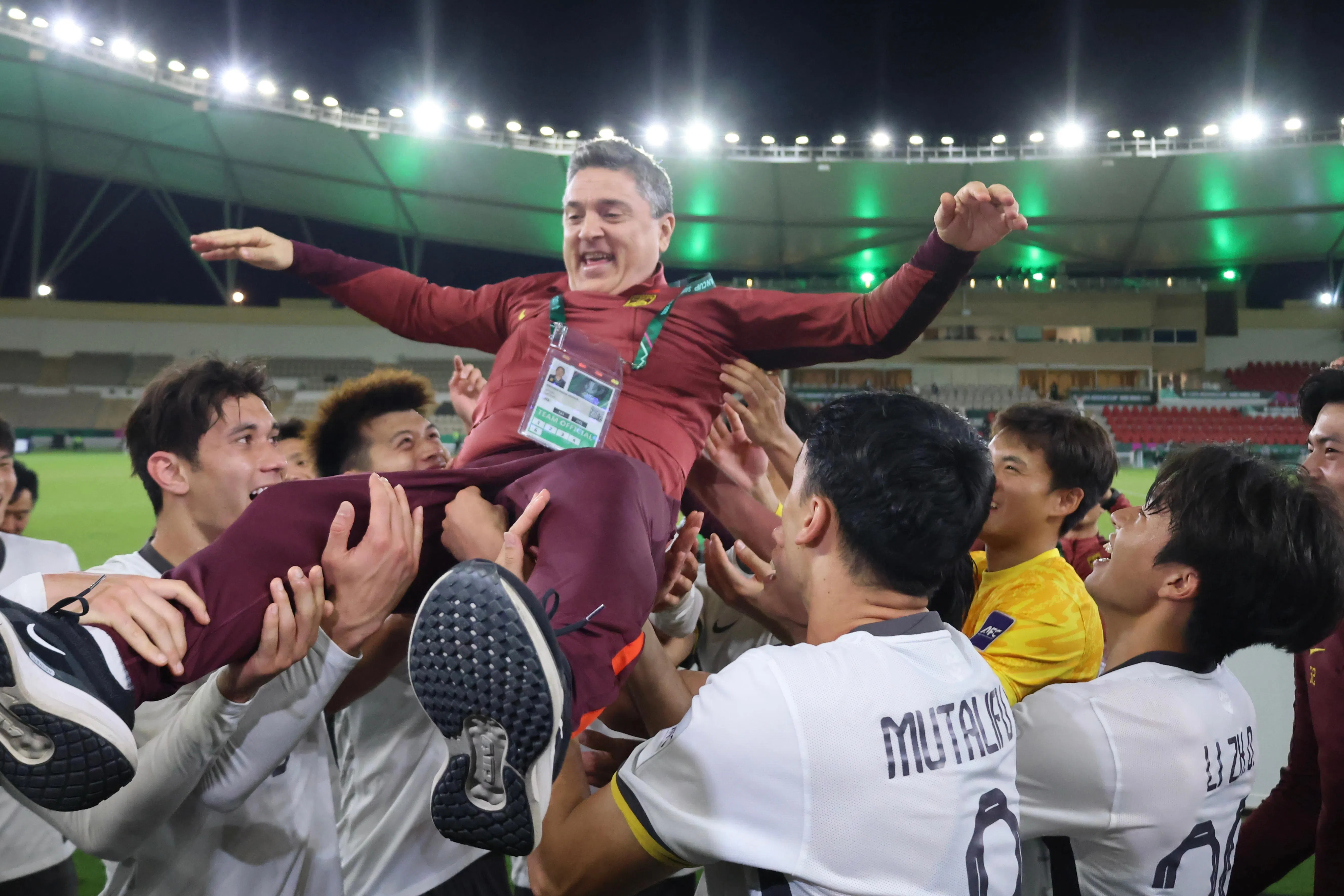 中国队球员在比赛后抛起主教练安东尼奥（上）庆祝。（新华社）