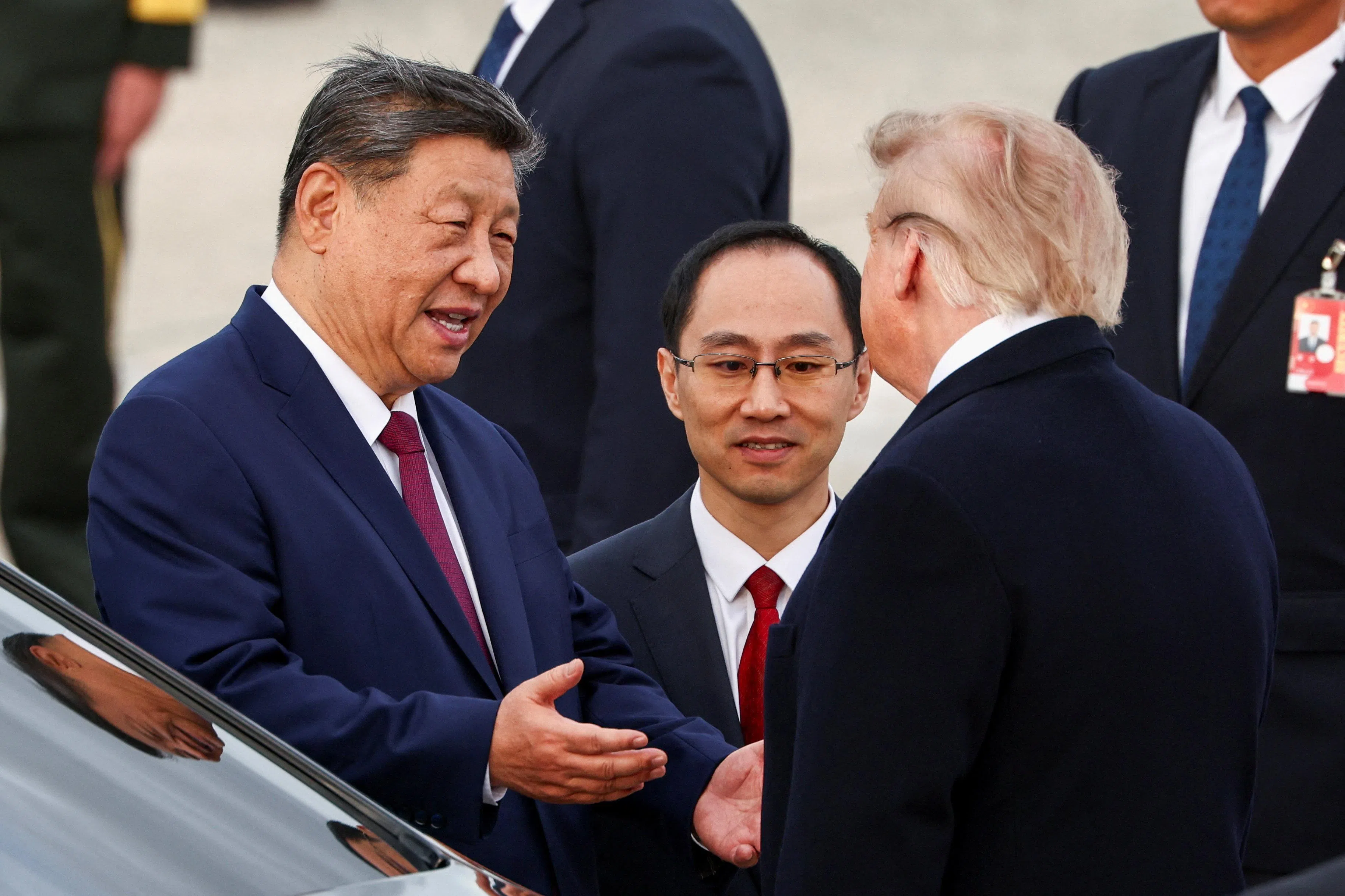 中国国家主席习近平（左）当地时间9月23日抵达美国后，在离开马里兰州安德鲁联合基地前，与美国总统特朗普在座车旁交谈。习近平面带笑容，一边说话一边做手势。（路透社）