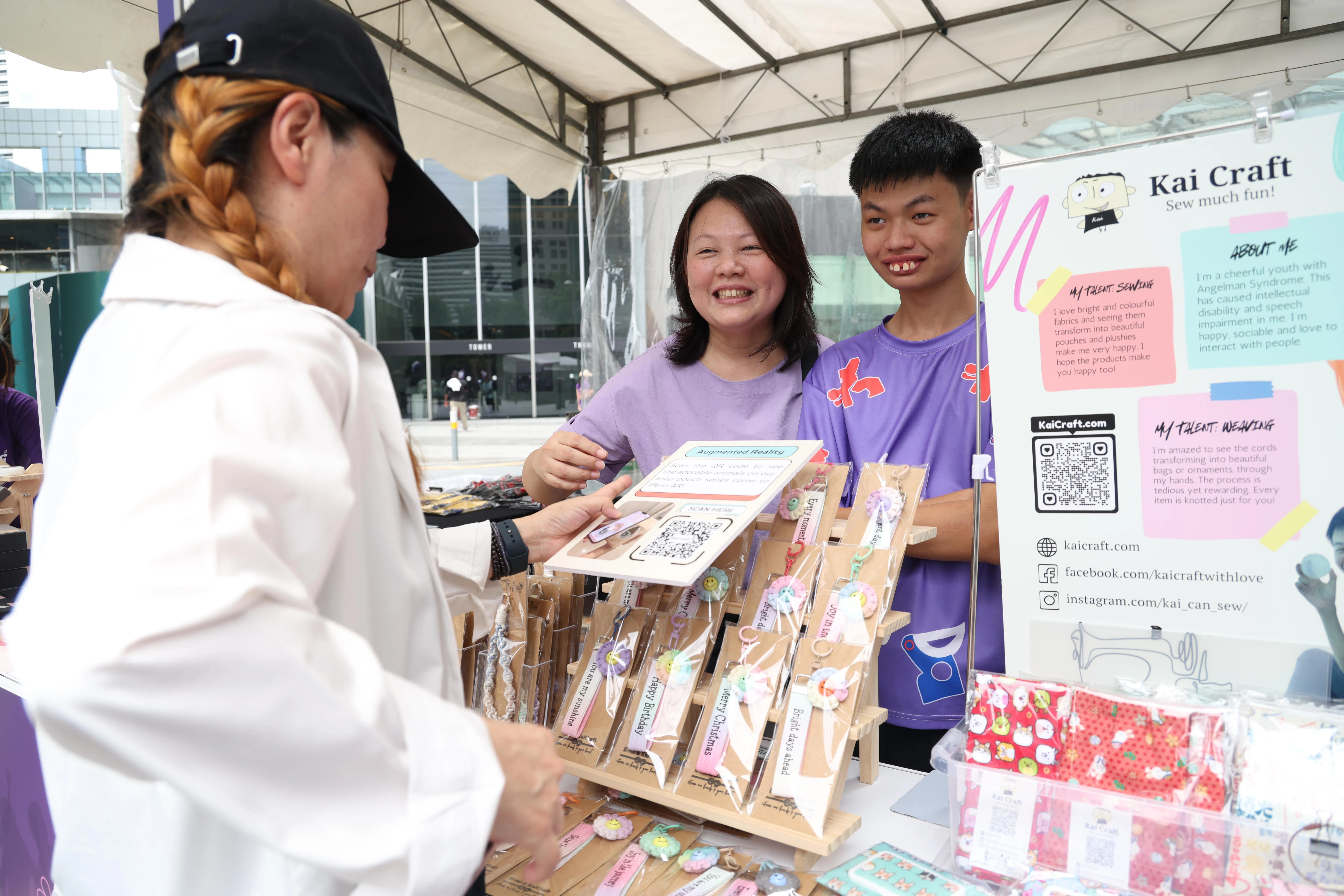 为了让儿子陈哲恺（右）学以致用，王丽蓉（左）设网站售卖他们缝制的产品，今年也在紫色行动摆摊，希望让更多公众认识特需孩子的能力。（郑一鸣摄）