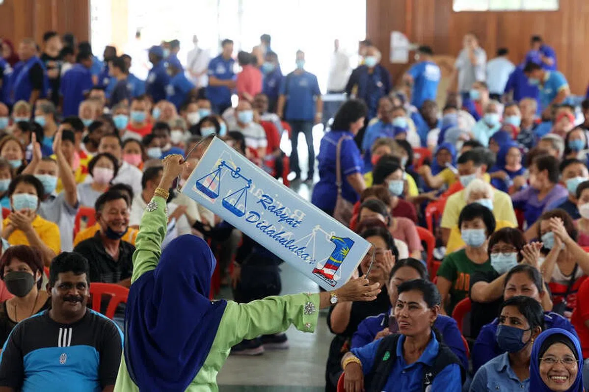 支持者高举国阵的标语和柔佛州务大臣翁哈菲兹为国阵在柔州候选人蔡智勇站台Labis（邝启聪摄）