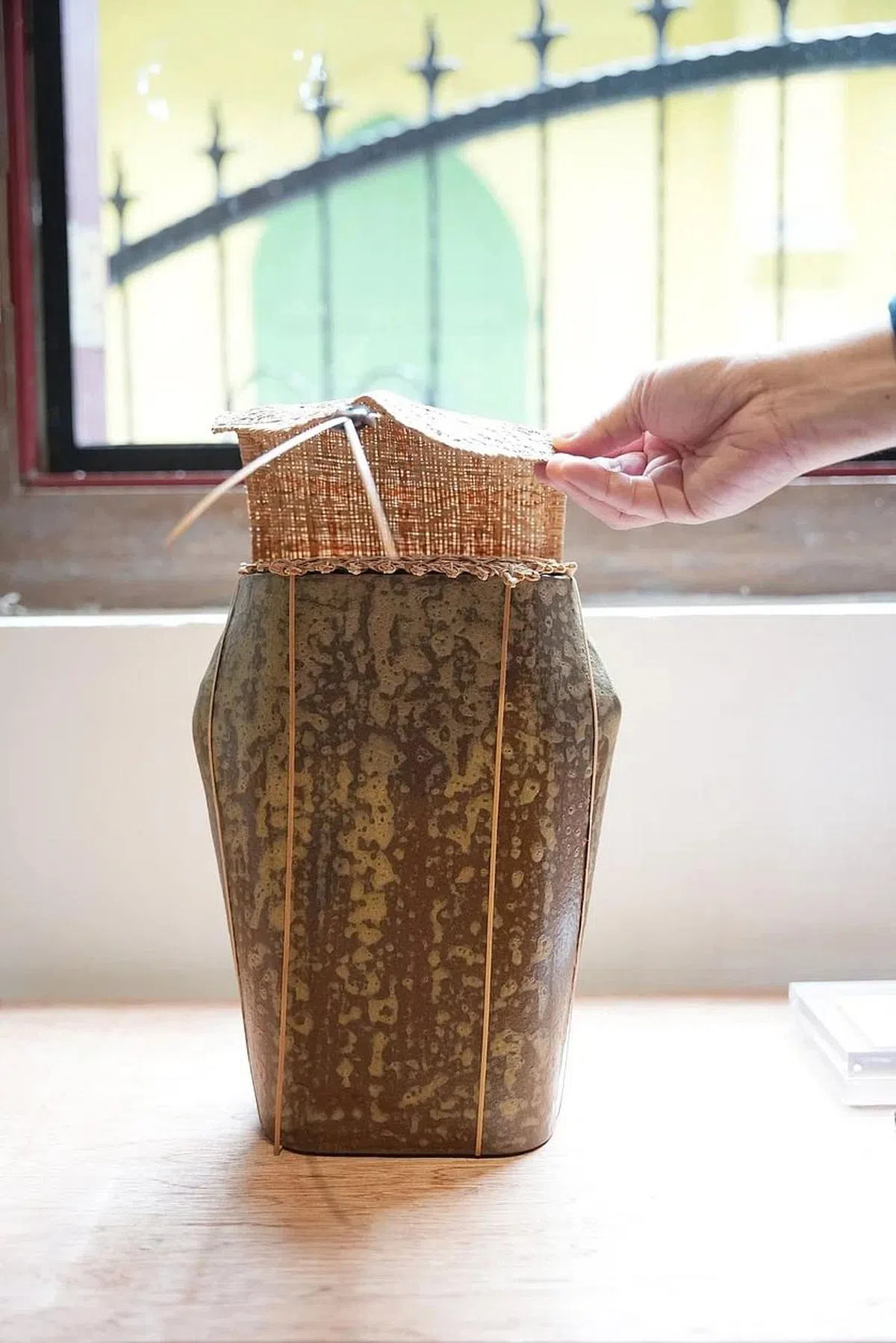 藤编艺术家黄思颖制造了有双层藤编盖的瓷器，邀请公众将他们一年的回忆写在纸上，然后卷起来投进瓷器里，就像电影《花样年华》里的梁朝伟对着树洞倾诉心事一样。（谢智扬摄）