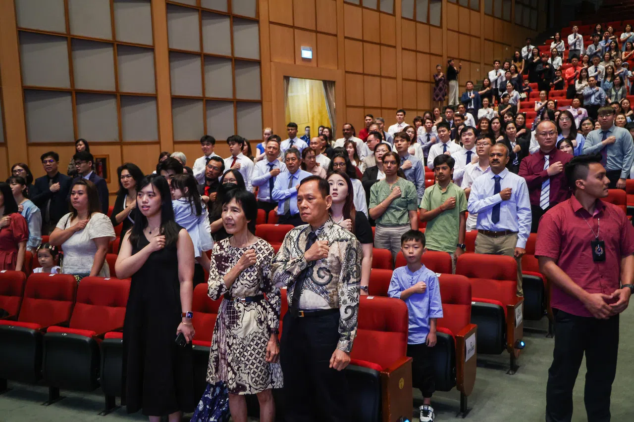 约有200名新公民在南洋理工学院的新公民仪式上，从国务资政李显龙手中接过新加坡公民权证书。仪式的其中一个环节是宣读信约和唱国歌，表示对国家的效忠和认同。（白艳琳摄）