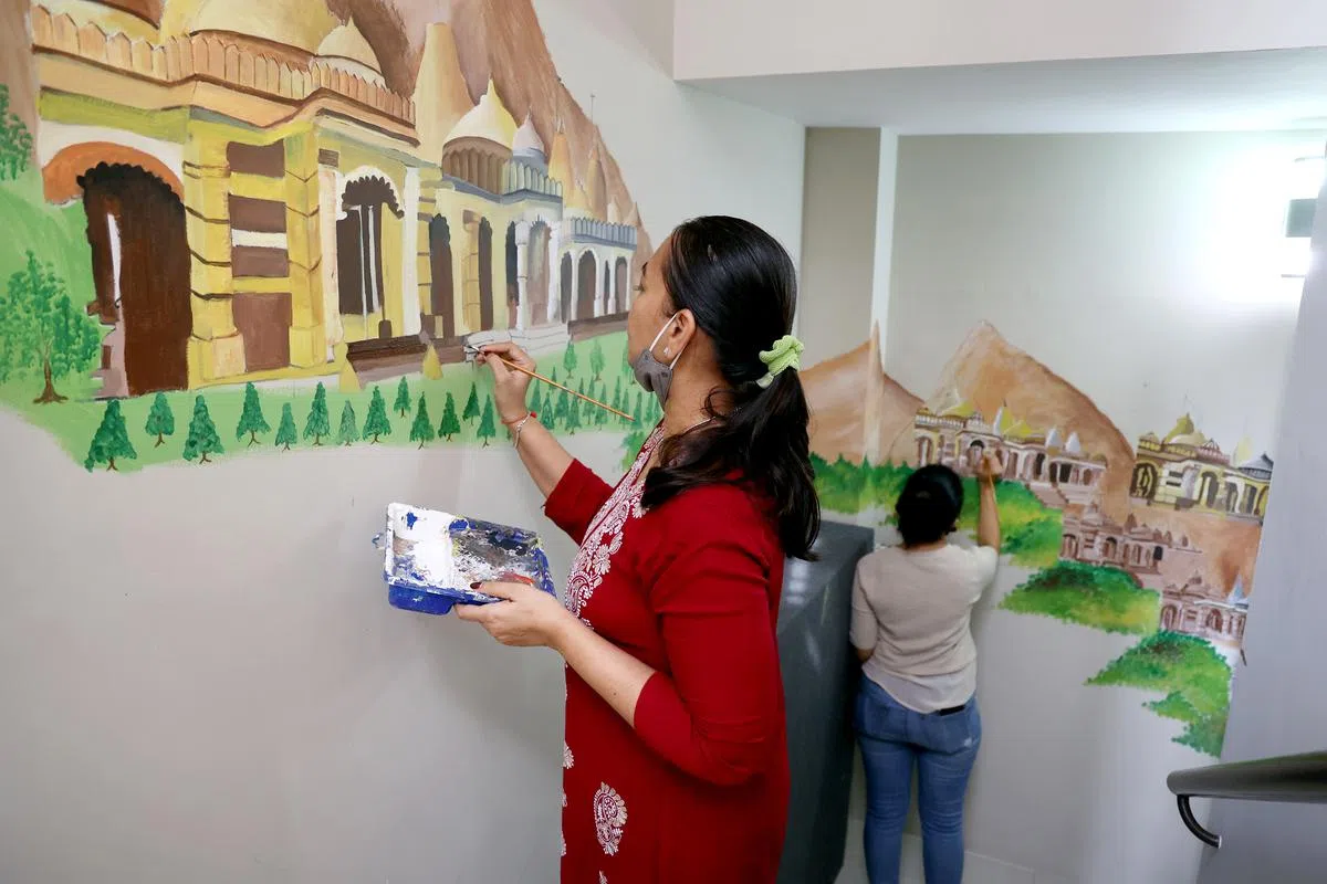 新加坡耆那教协会将庆祝成立50周年，女信徒忙着墙上绘制宗教故事和庙宇的壁画，为活动中心增添色彩。（严宣融摄）