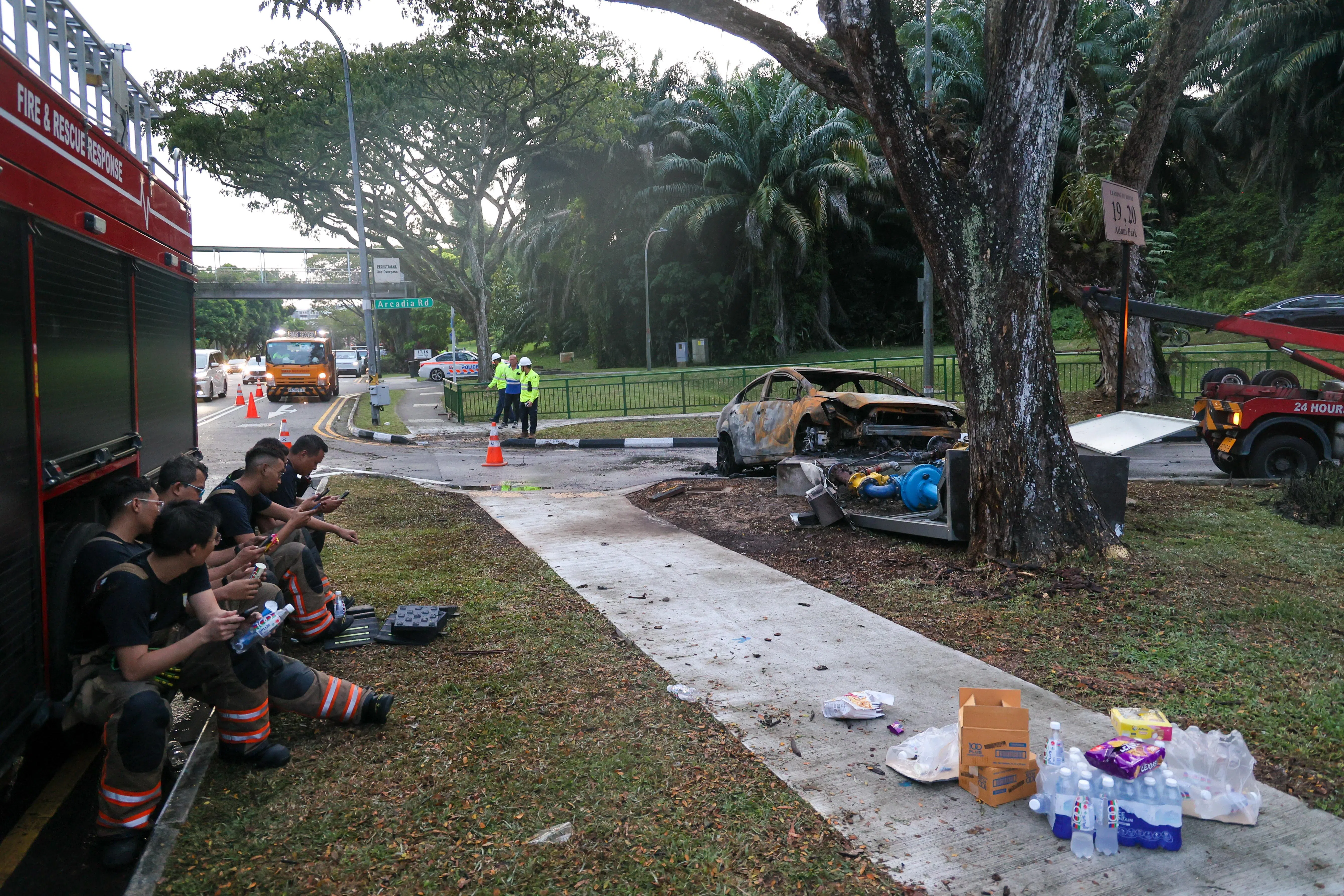 火势被扑灭后，警方还留在现场指挥交通，消防人员也在路旁稍作休息。（张俊杰摄）