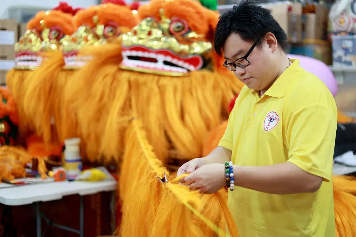 新加坡精武体育会副司理高焯洪说，越来越少年轻人愿意学习传统工艺，手工制作舞狮的手艺濒临失传。图为林顺立在学做舞狮头。（龙国雄摄）