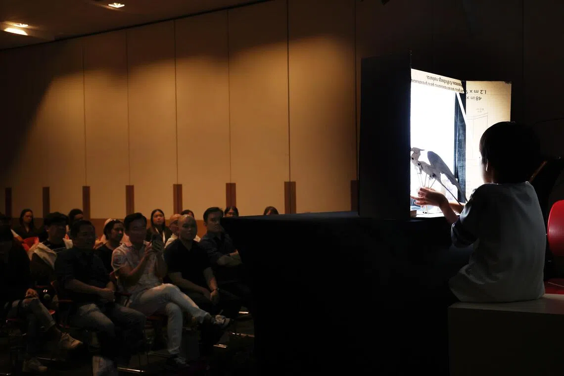 一名寄养儿童在颁奖礼上以影子木偶表演呈现故事，精彩演出获得观众热烈掌声。（邬福梁摄）