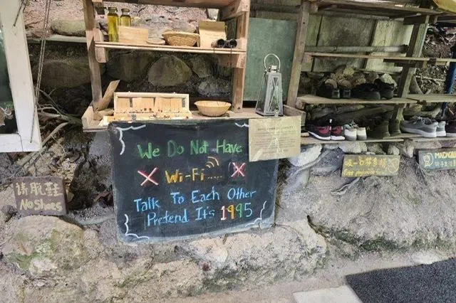 进入咖啡座前得脱鞋，鞋柜旁的“提示”请都市人暂时忘我。上山，就不要急于找网络了。（君盈绿摄）