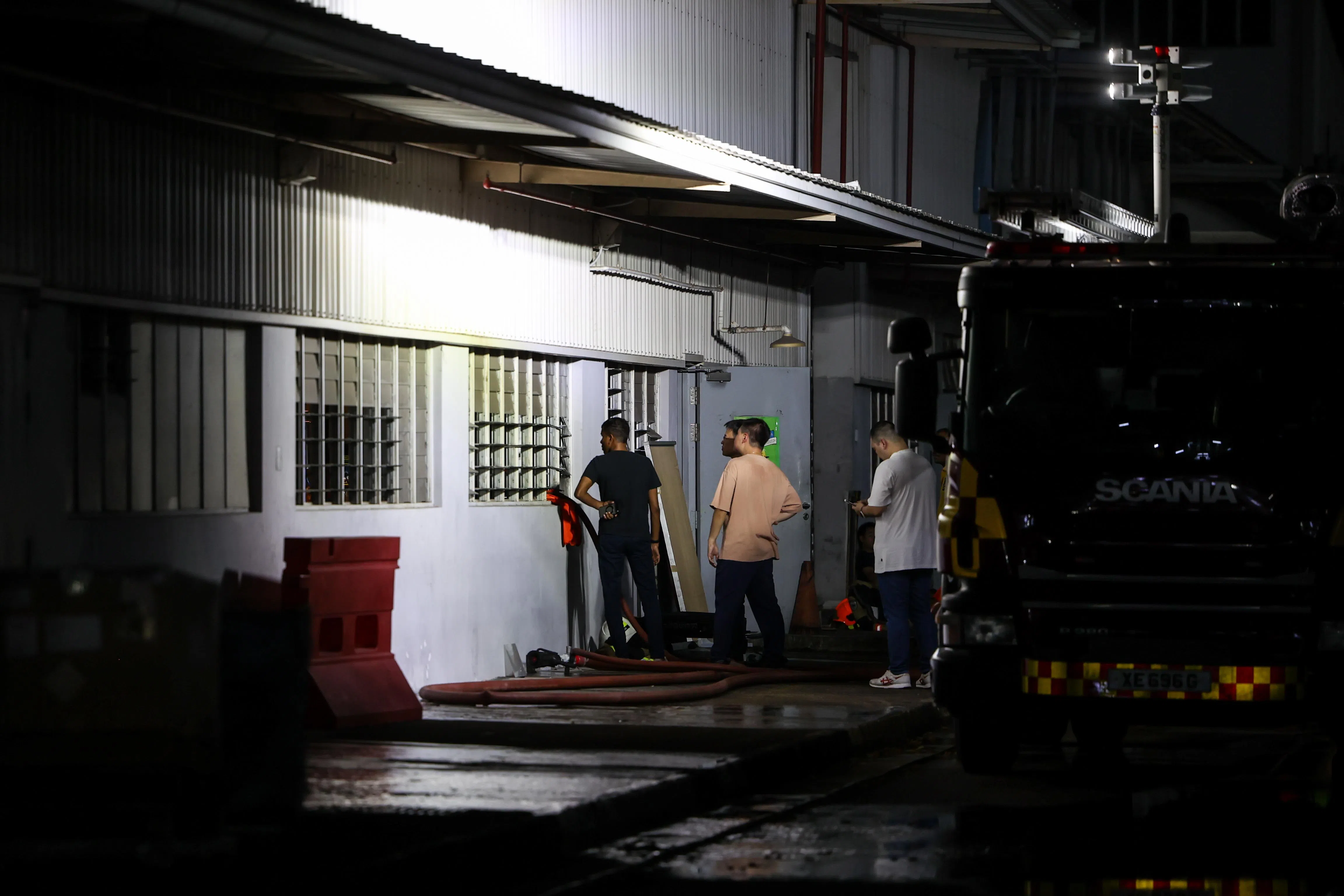 现场已不见火光或浓烟，有几个相信是工厂的工作人员，透过窗户观察情况。（关俊威摄）