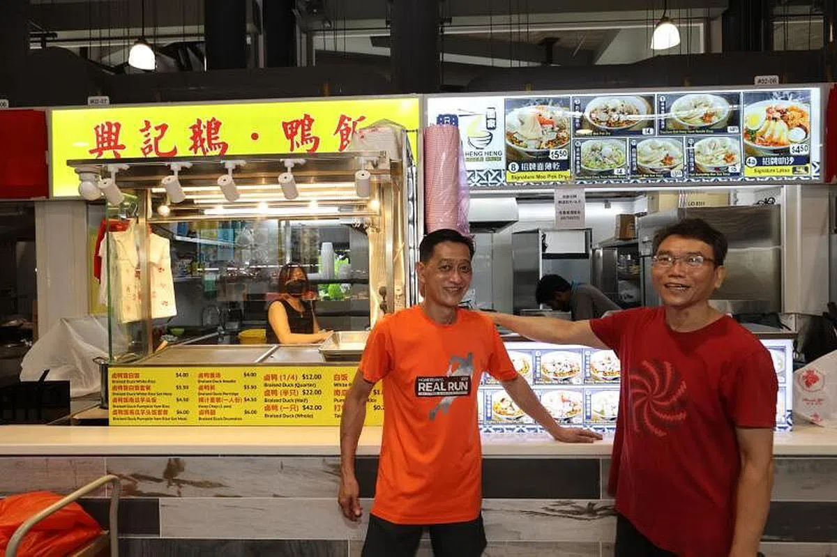 兴兴面家摊主芮宗厉（右）与兴记鹅鸭饭摊主倪顺林。（邝启聪摄）