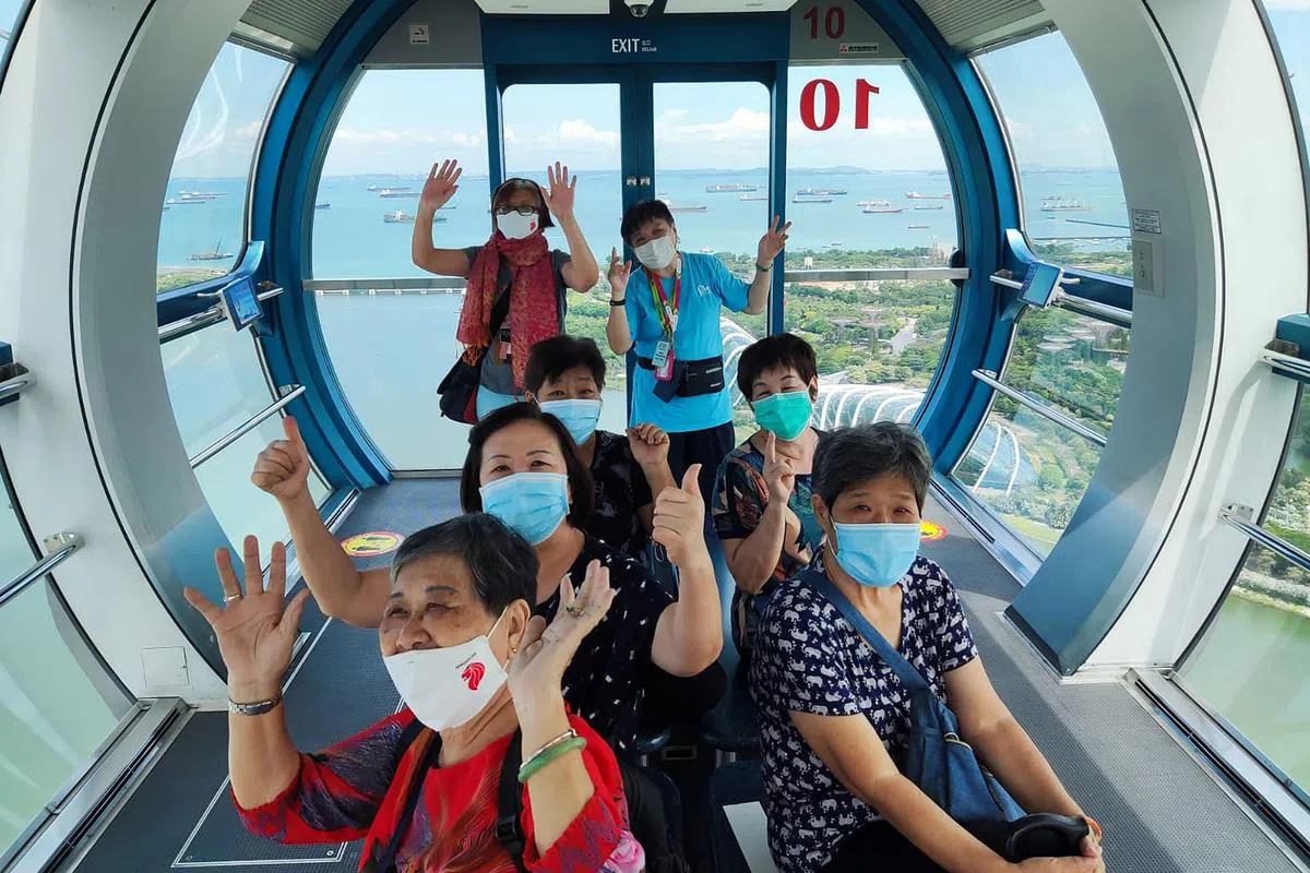 从Pay It Forward计划受益的年长人士，开心地乘坐新加坡摩天观景轮欣赏风景。（图/商家提供）