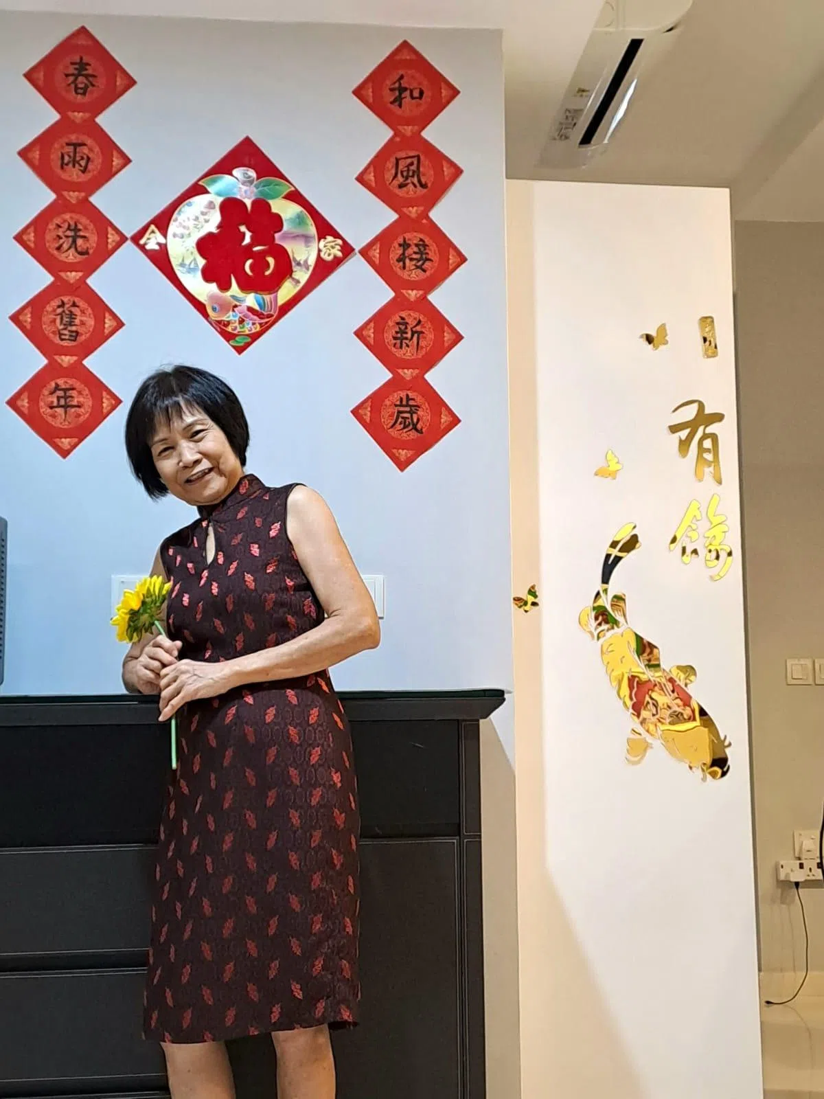 冼凤桂为迎接新年，自己手工做旗袍、写春联。（受访者提供）