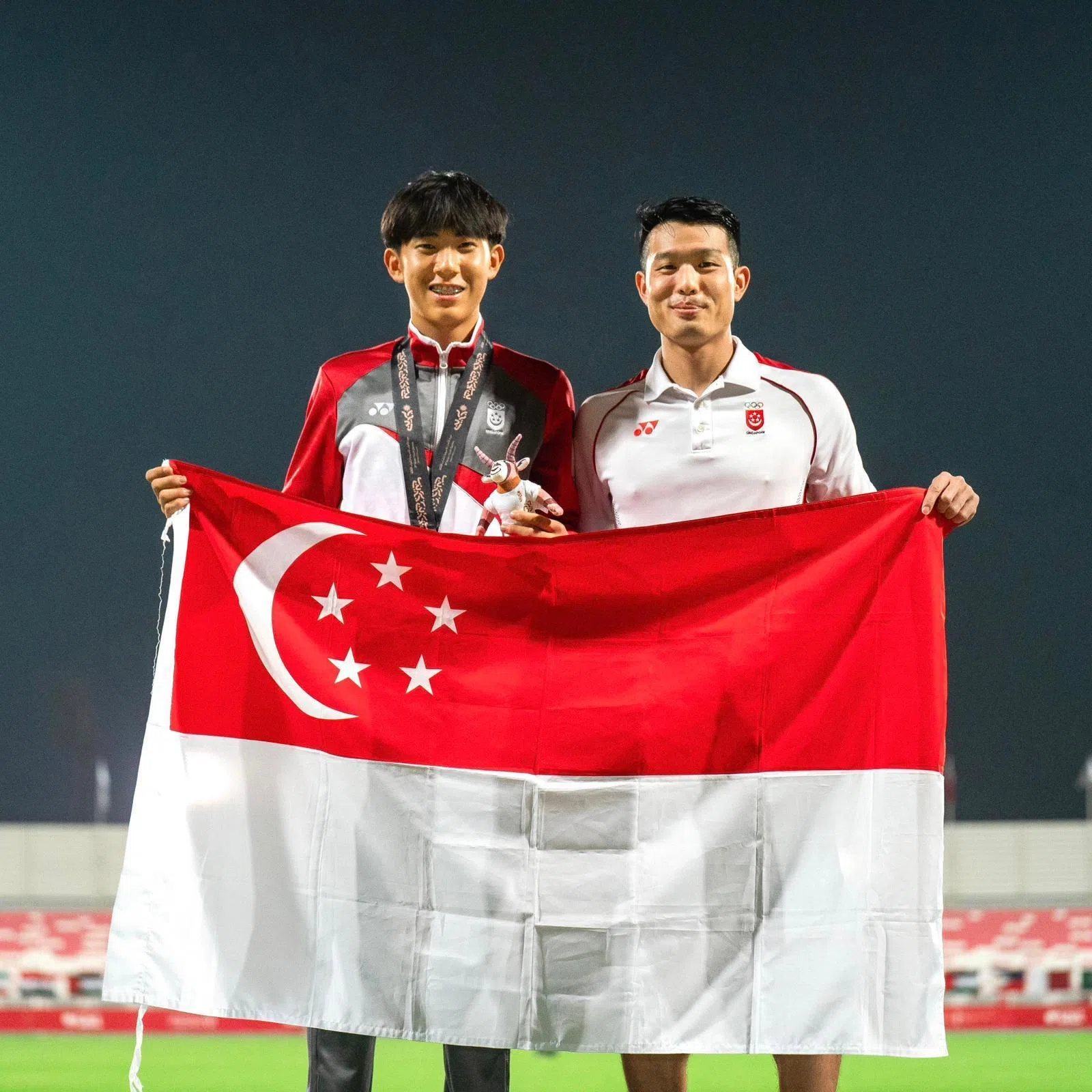 就读维多利亚学校的中四学生江云帆（左）在完成撑杆跳比赛后，就马不停蹄地回国准备下周的O水准考试。他的教练洪国竣（右）也是维多利亚学校的校友。（受访者提供）