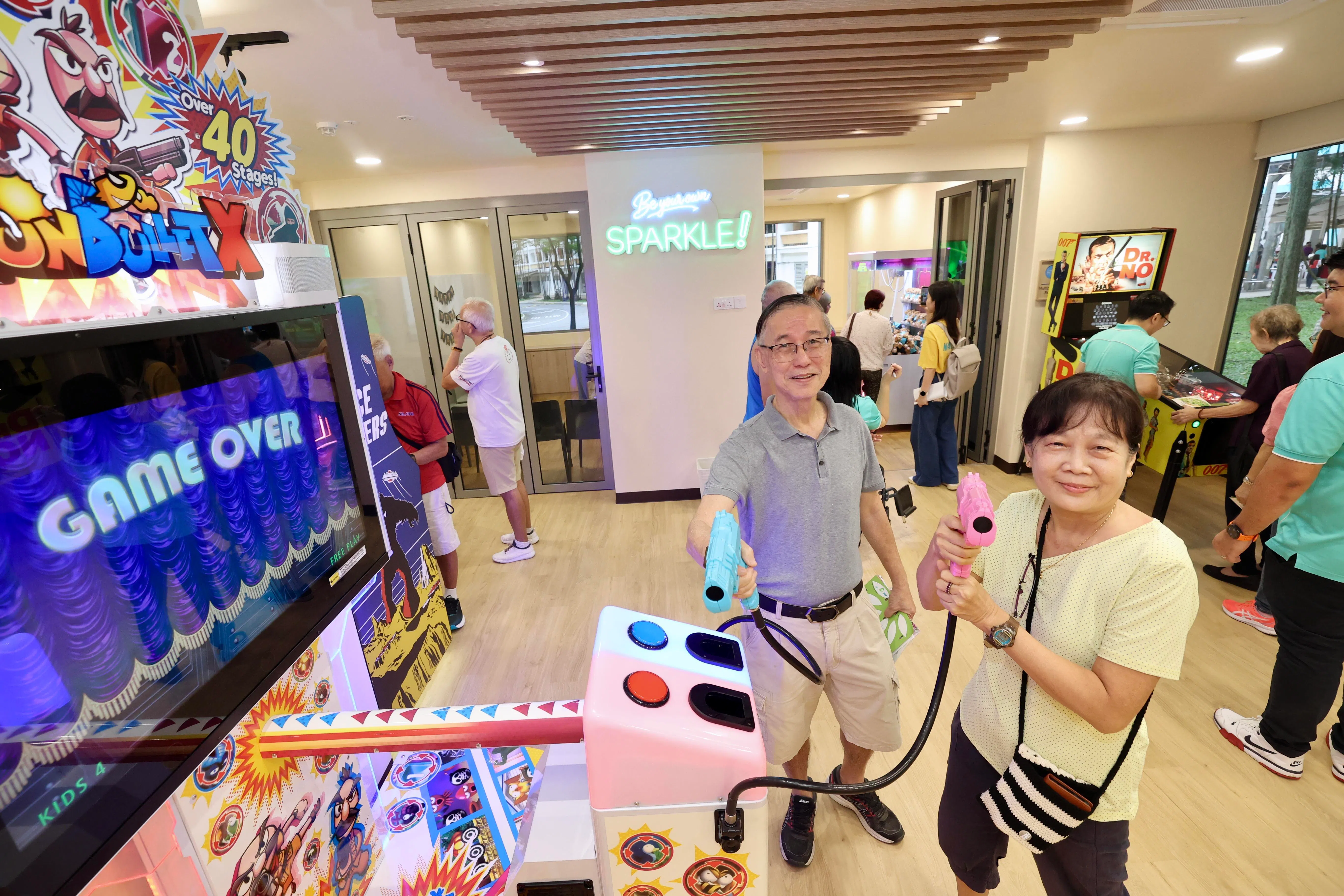 郭俊福（左）与妻子关明琼兴致勃勃地试玩游戏，觉得通过游戏可锻炼反应能力。（邝启聪摄）