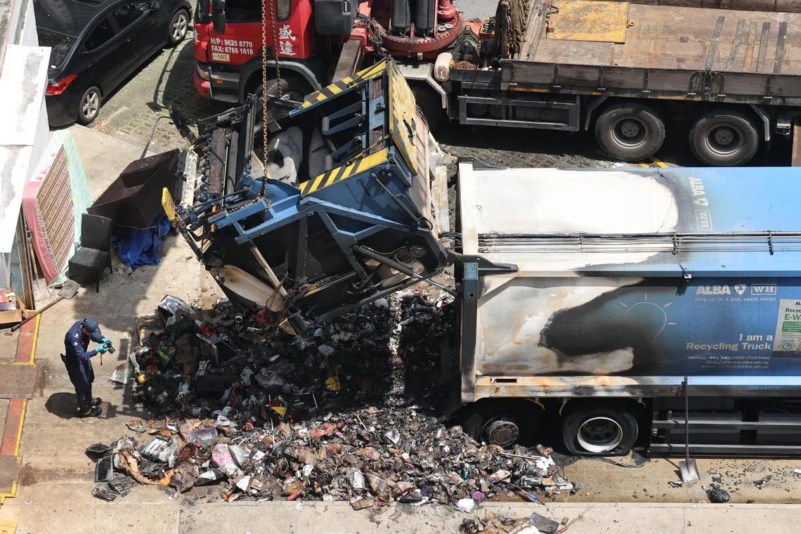 大火扑灭后，垃圾槽附近留下满地狼藉的焦黑废品。（邝启聪摄）