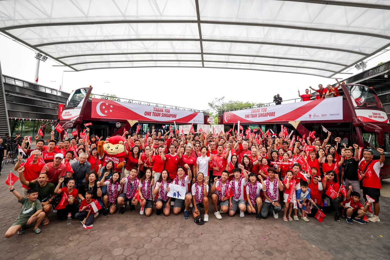 巴士出发展开游行前，聚集在新加坡体育城的支持者与我国健儿和嘉宾们大合照。（叶振忠摄）