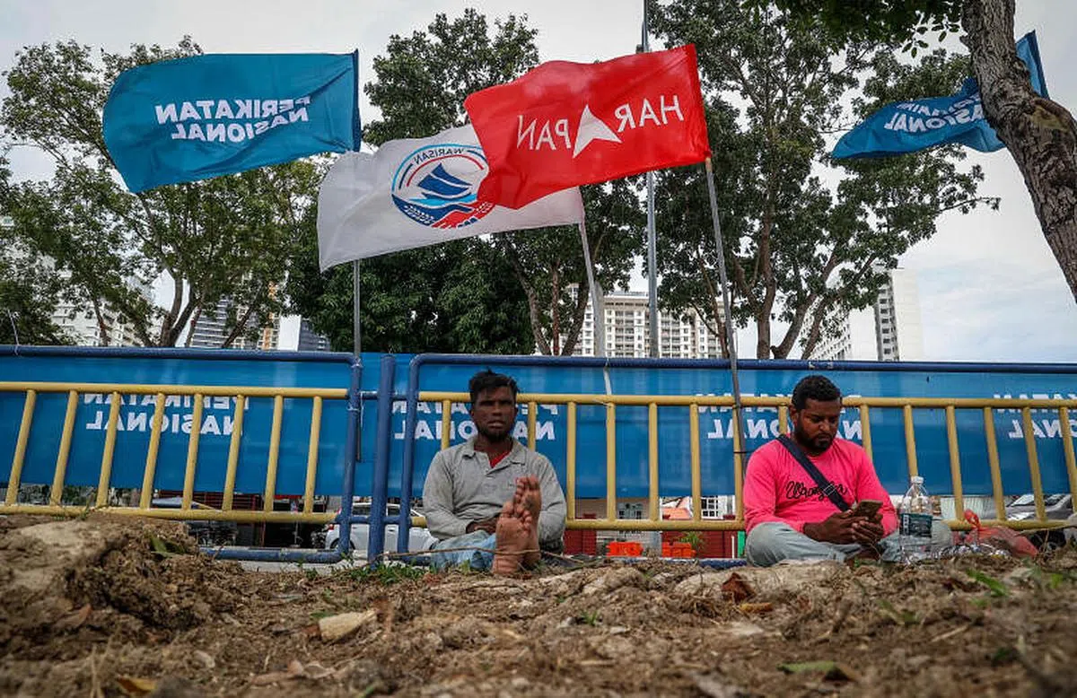 马来西亚大选战火激烈，多地上演多角战。11月9日，在希望联盟的政治堡垒槟州，工人小憩的路旁挂满各政党联盟的旗帜。（叶振忠摄）