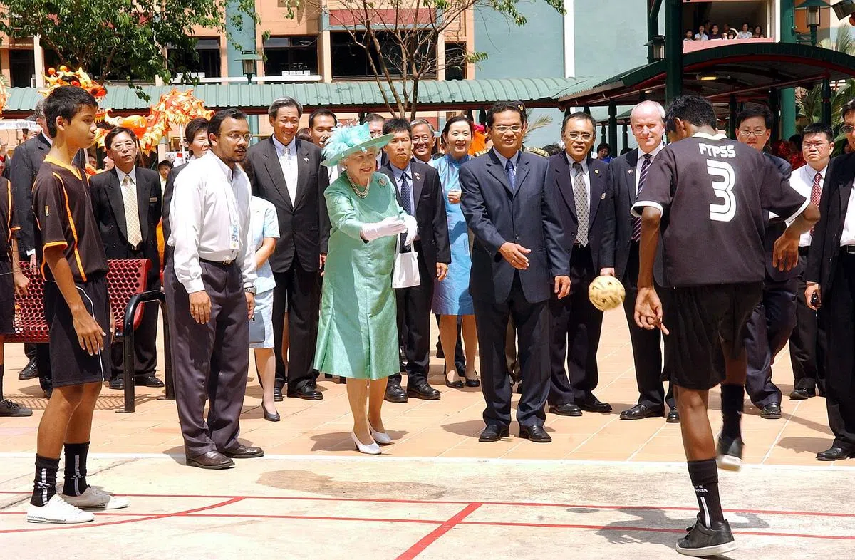 2006年3月17日，英女王伊丽莎白二世在参观大巴窑7巷组屋时向一名运动员投掷藤球。她曾在1972年、1989年和2006年三次访问新加坡。（档案照）