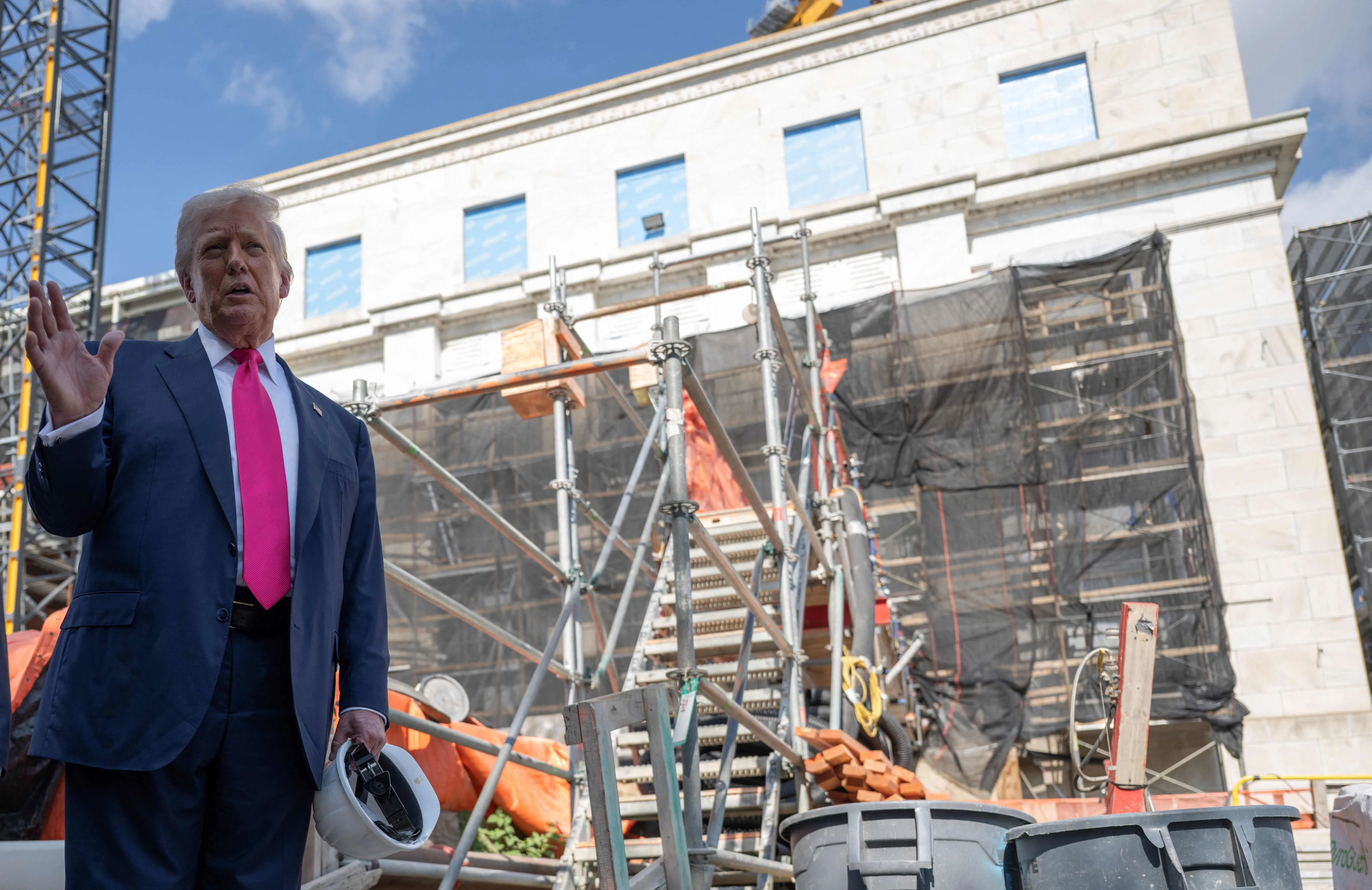 特朗普在美国联邦储备局总部的翻修工程工地回答记者的提问。（法新社）