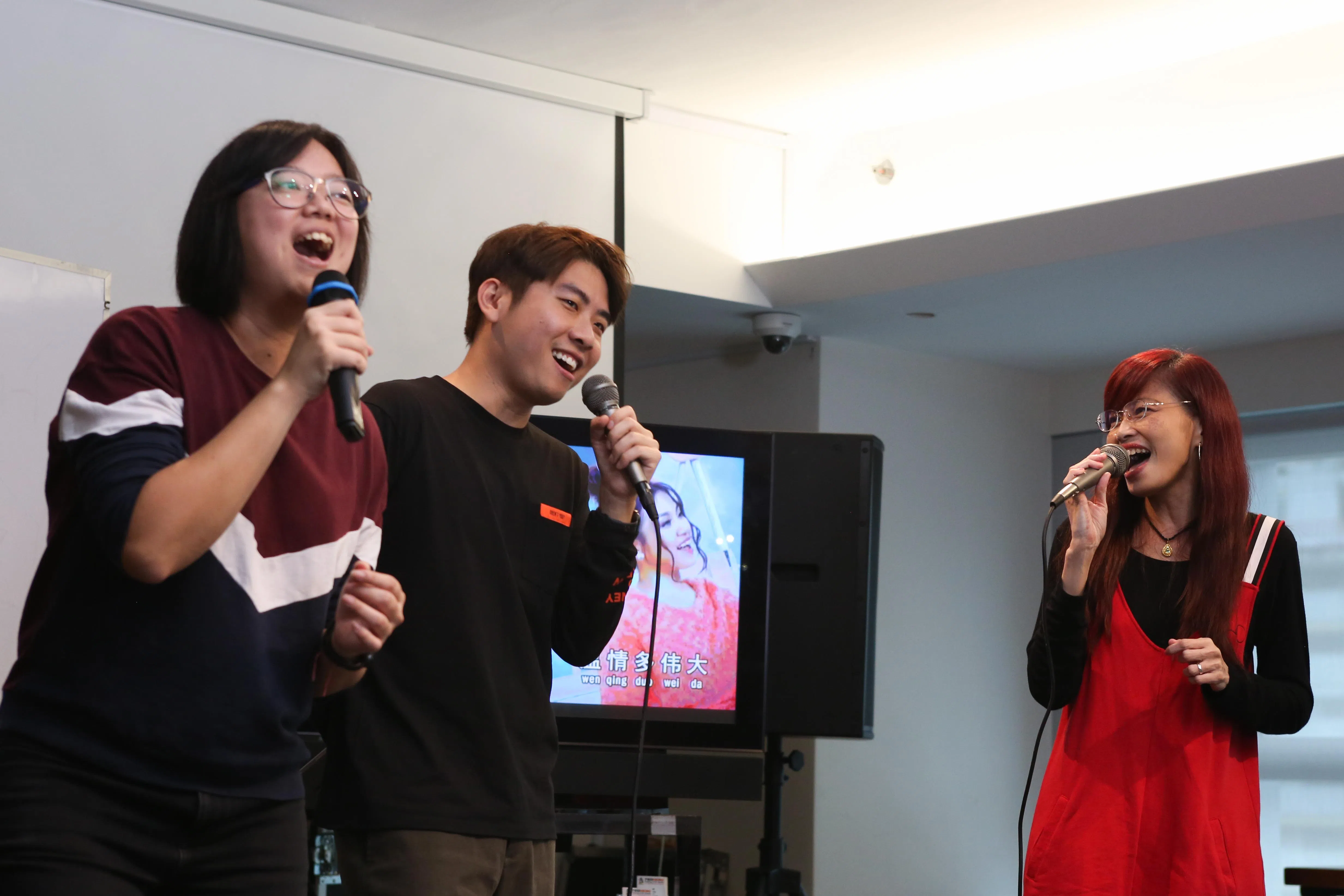 在《疫起过生活》的歌唱课程中，导师林欣婷（右）通过网络直播教导歌唱基本功，《新闻抢先看》主持人李丽敏（左）和96.3好FM电台节目制作人余思远也边学边唱。（档案照片）