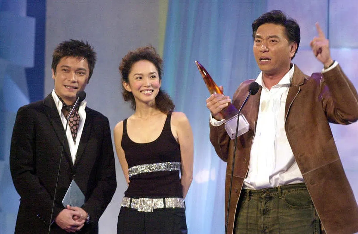 黄奕良（右起）从范文芳、罗嘉良手上领过奖座，开始“大发伟伦”，祸从口出。（档案照）