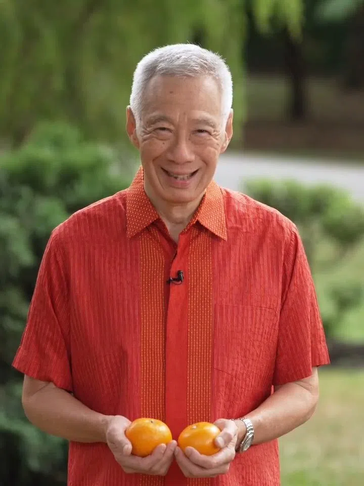在国务资政李显龙配合斋戒月推出的视频里，他先是手捧一对柑，以华语向人们表达新春佳节的祝愿。（资政脸书视频截图）